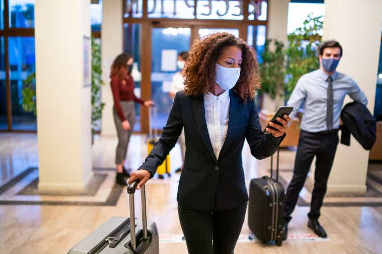 Hotel guests wearing protective face mask and keeping social distance during COVID-19