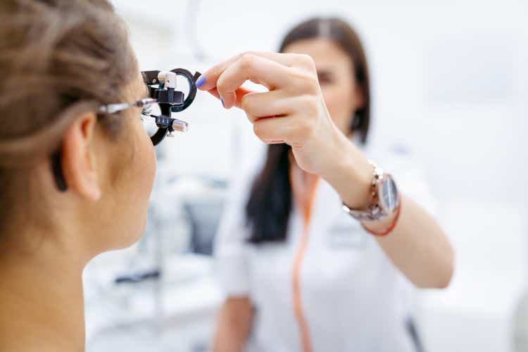 Female eye doctor testing patient"s eyesight with phoropter