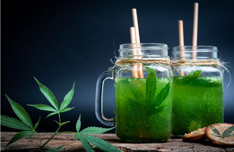 Green vegetable smoothie with marijuana in a jar