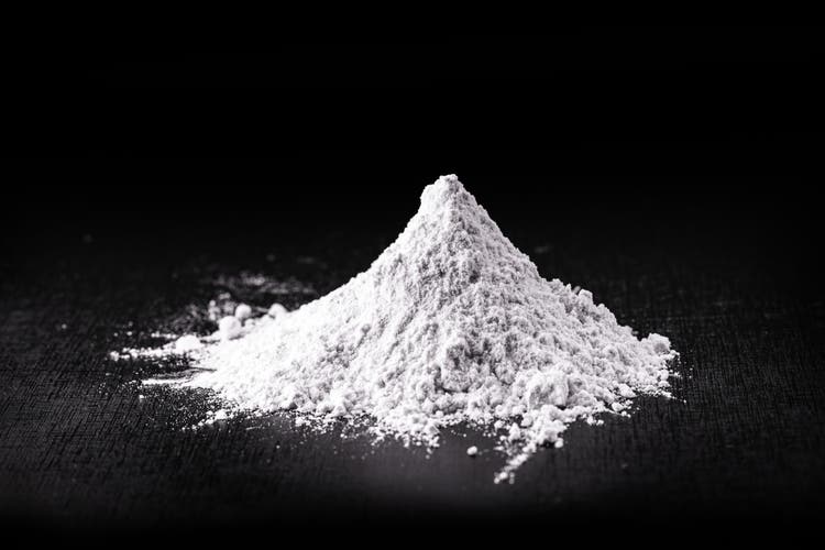 Titanium dioxide (TiO2) powder for cosmetics, isolated black background