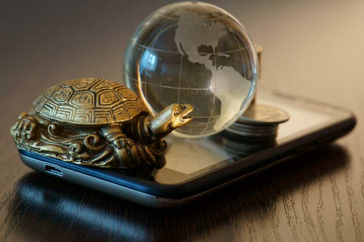 Metal turtle with a small glass globe on the smartphone.