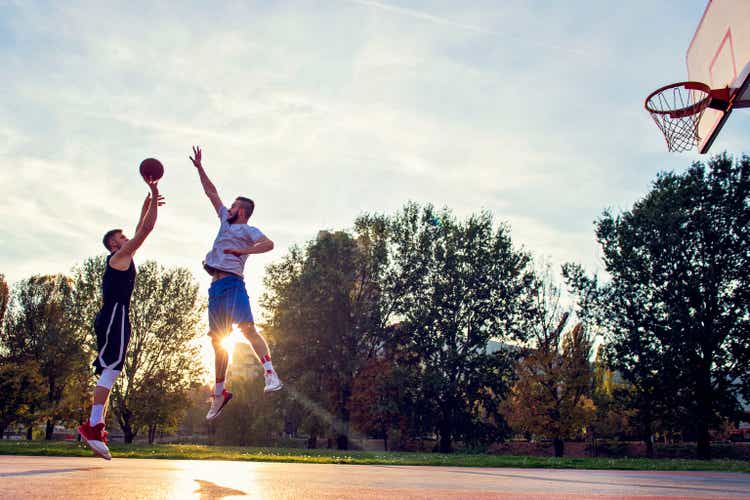 Two street basketball players playing hard on the court