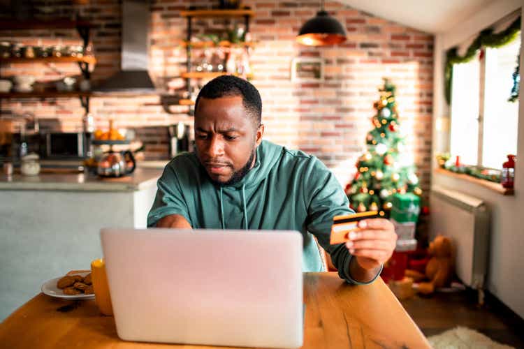 Young man doing online Christmas shopping