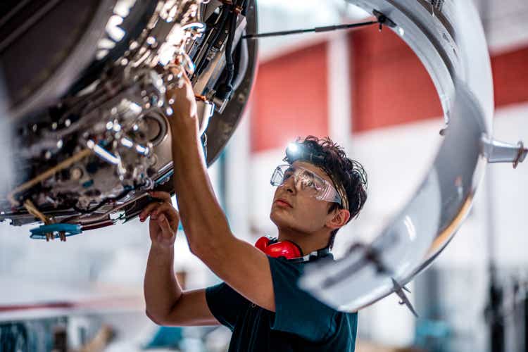 Aircraft Mechanic checking jet engine of the airplane