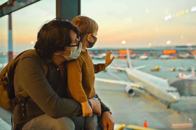 Family in protective face masks in airport during COVID-19 pandemic
