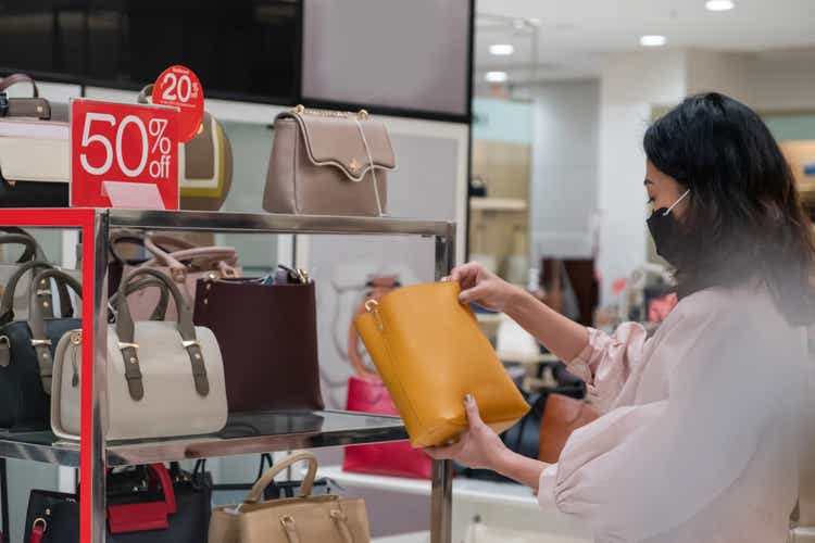 Chinese woman checking a leather handbag on sale