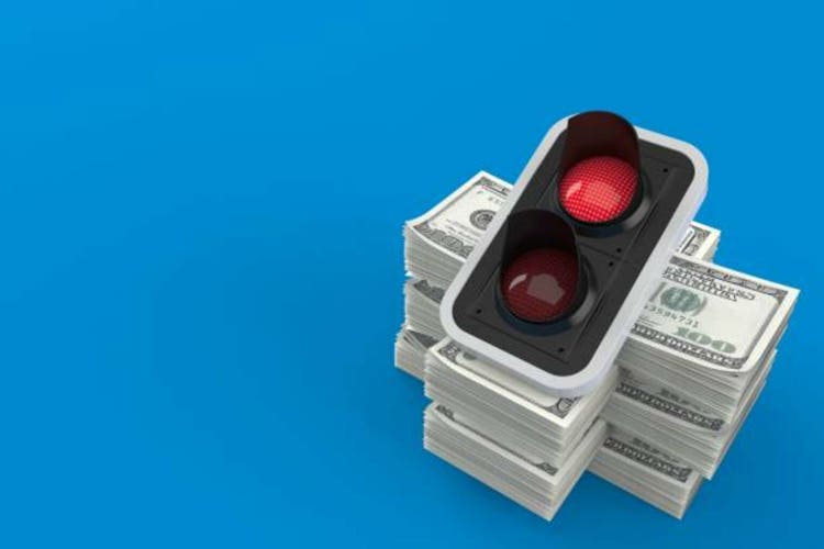 The red traffic light on the pile of money