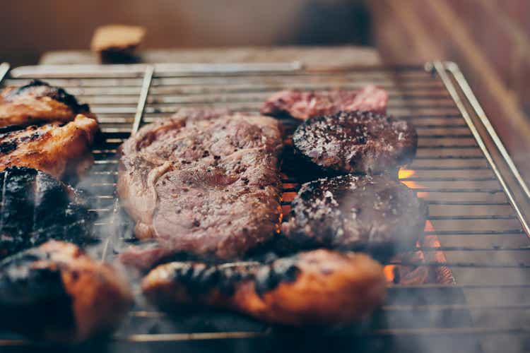 Meat cooking on open barbecue grill