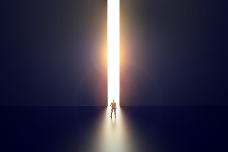 Businessman walking towards bright opening in concrete wall. Opportunity and success concept. 3d render