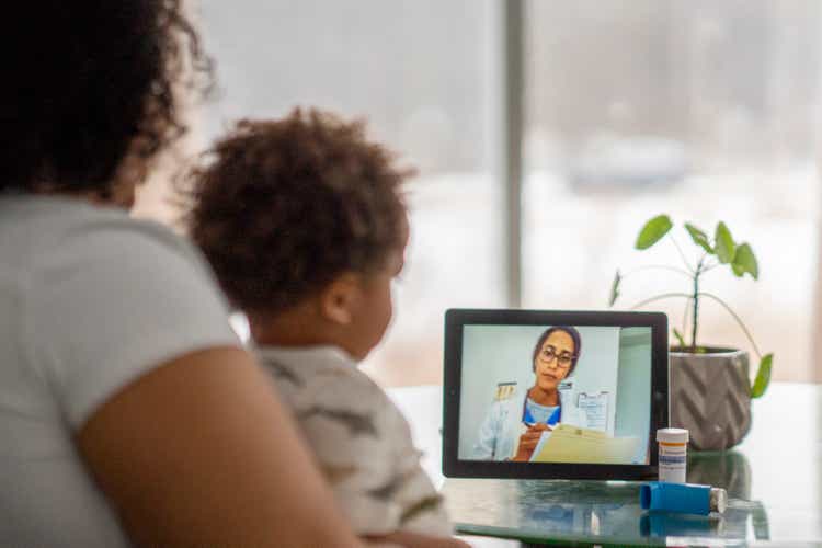 Mother on a remote medical call with a doctor about her sick child