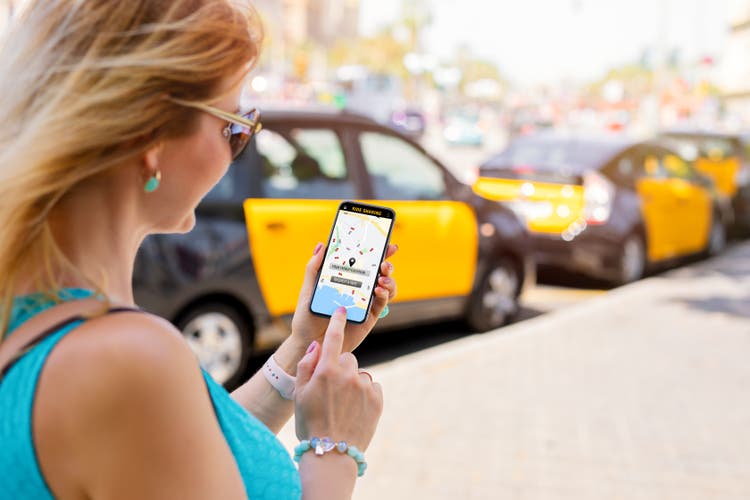 Woman using ride sharing app on phone
