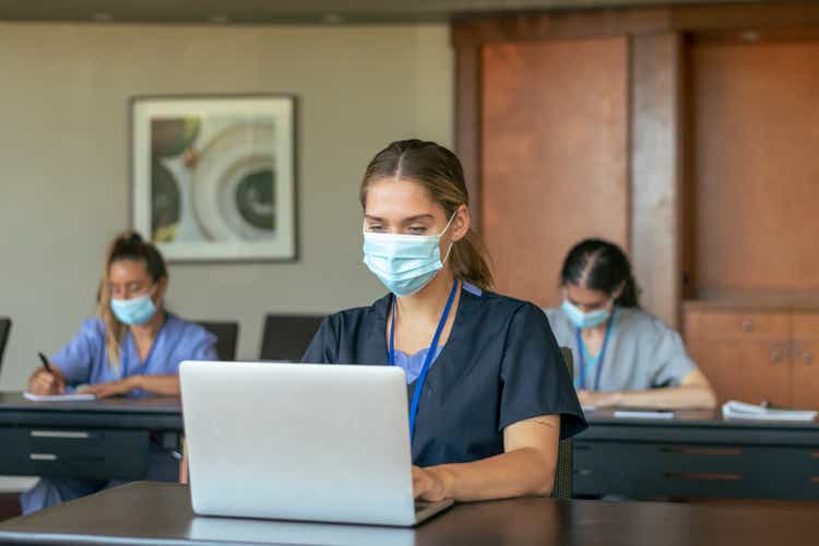Nursing students wearing protective face masks attending class