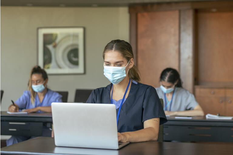 Nursing students wearing protective face masks attending class