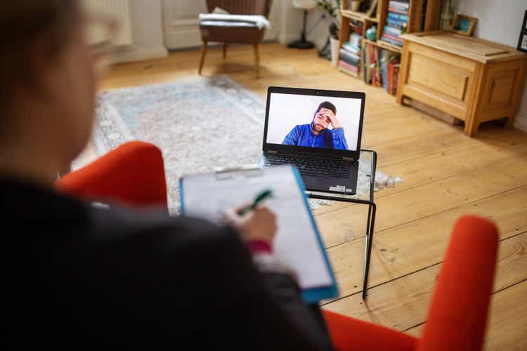 Man having a cognitive behavioral therapy video call with mental health professional