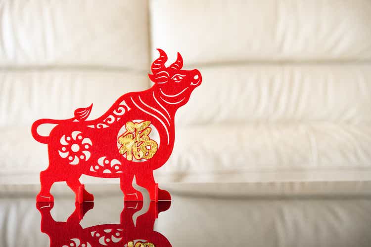 an ox mascot as symbol of Chinese New Year of the Ox in front of a sofa the Chinese means good luck