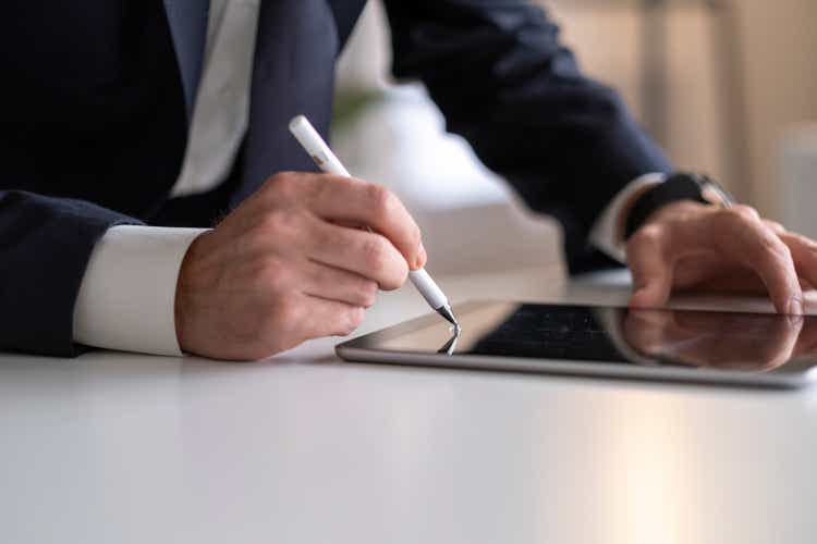 Businessman Signing Digital Contract On Tablet Using Stylus Pen