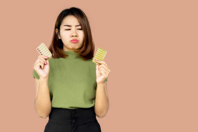 Asian woman confuse and hesitate choosing contraceptive pill