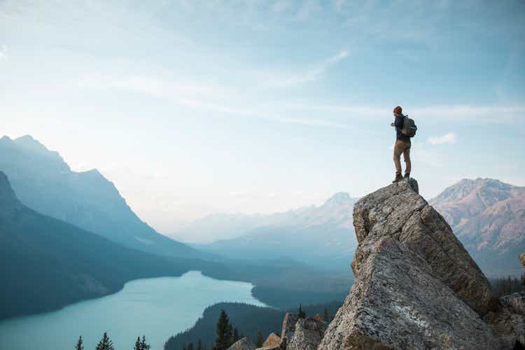 A man standing on a rocky point overlooking Peyto Lake.