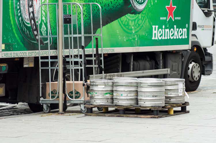 Heineken beer barrels from delivery truck parked in the street near restaurant