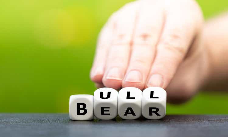 Symbol for a positive trend at the stock market. Hand turns dice and changes the word Bear to Bull.