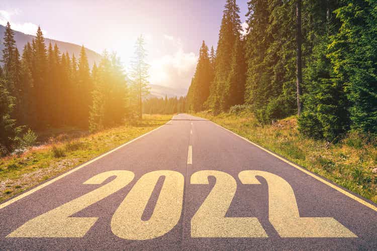 Empty asphalt road and New year 2022 concept. Driving on an empty road in the mountains to upcoming 2022. Concept for success and passing time.
