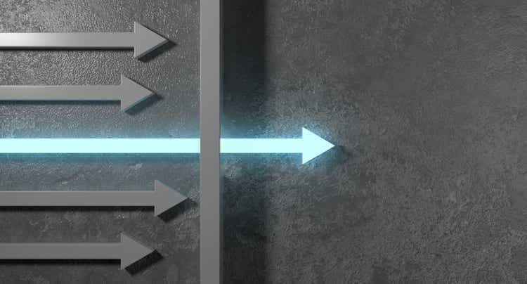 Glowing arrow breaking through wall on concrete background. Breakthrough and growth concept.