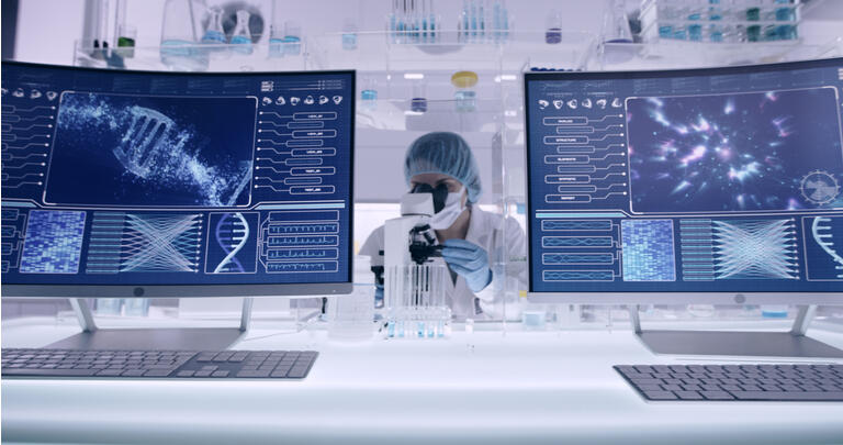 Female studying DNA samples. Computer screens with DNA sequences