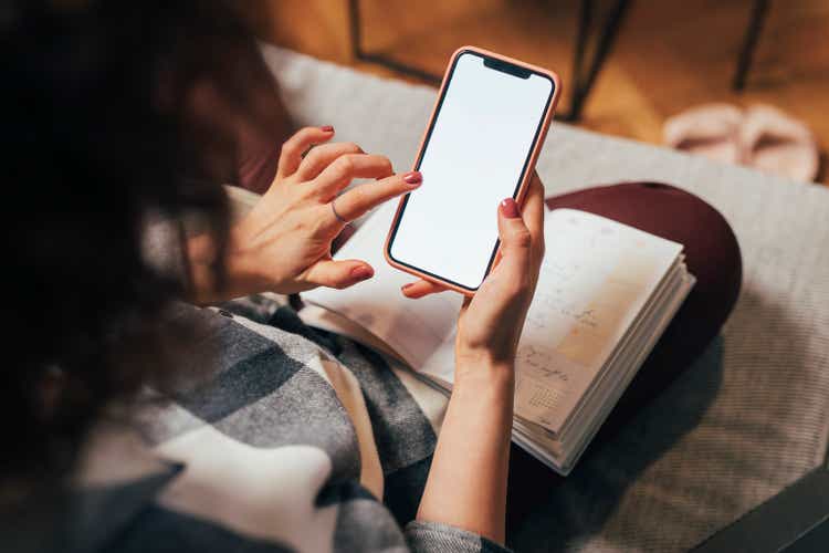 Anonymous Woman Using her Mobile Phone at Home (Blank Screen, Copy Space)