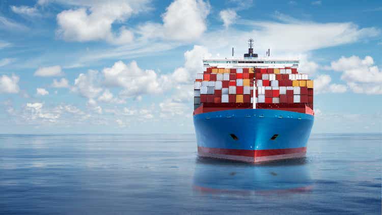 Front view from bow of a large blue shipping container ship.