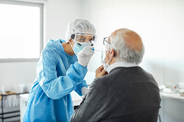 Doctor taking swab test sample of elderly patient, PCR.