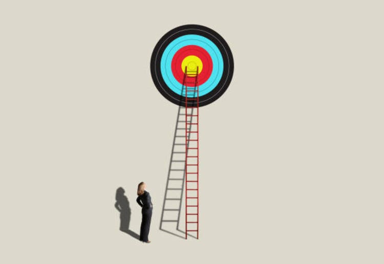 Woman Looking Up At Ladder Leading To Target