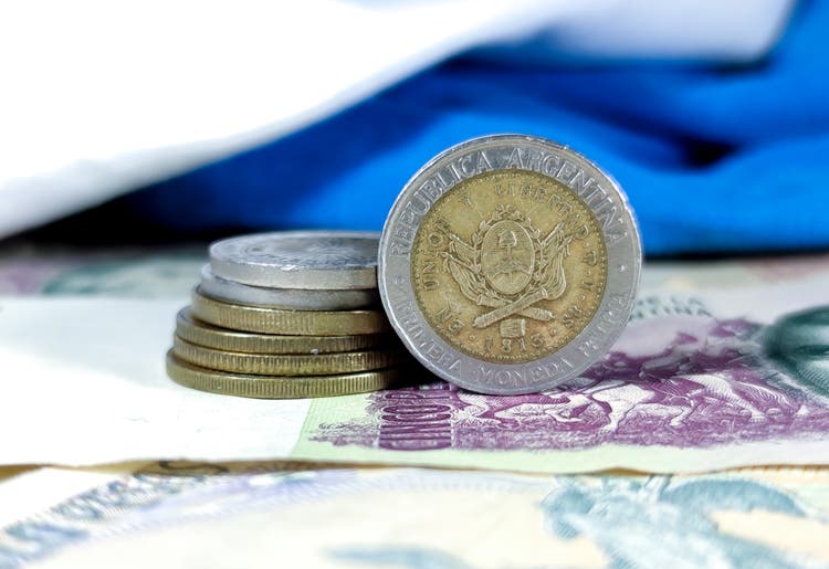varios billetes de dinero y la moneda de pesos de Argentina sobre un fondo azul y blanco. espacio para el texto. dinero de Argentina. ganar dinero. pesos, Moneda, Dinero, Argentina