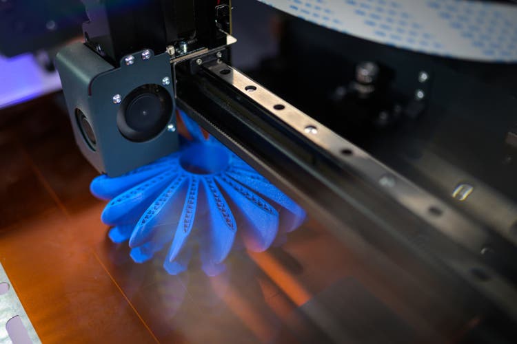 Close-up of printing head adding further layers of filament to propeller