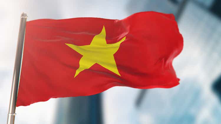 National Flag of Vietnam Against Defocused City Buildings