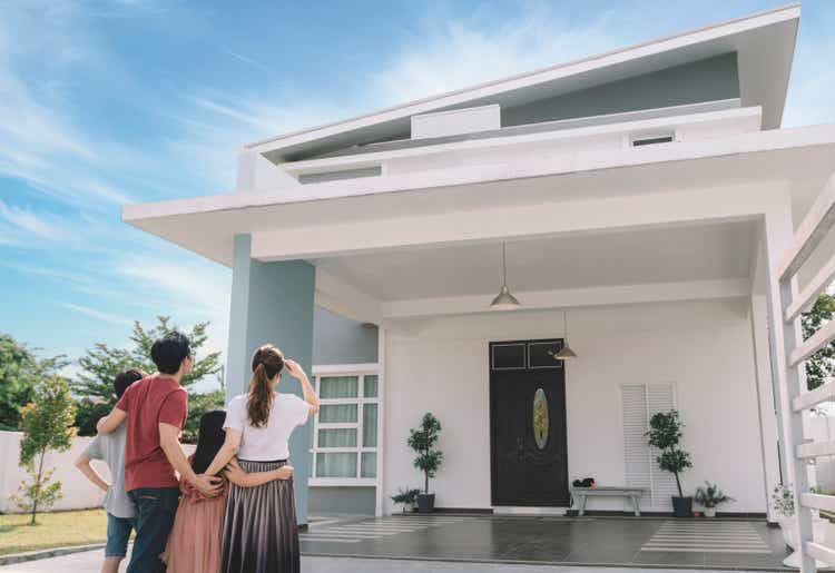 asian chinese family looking at their new house with their daughter and son