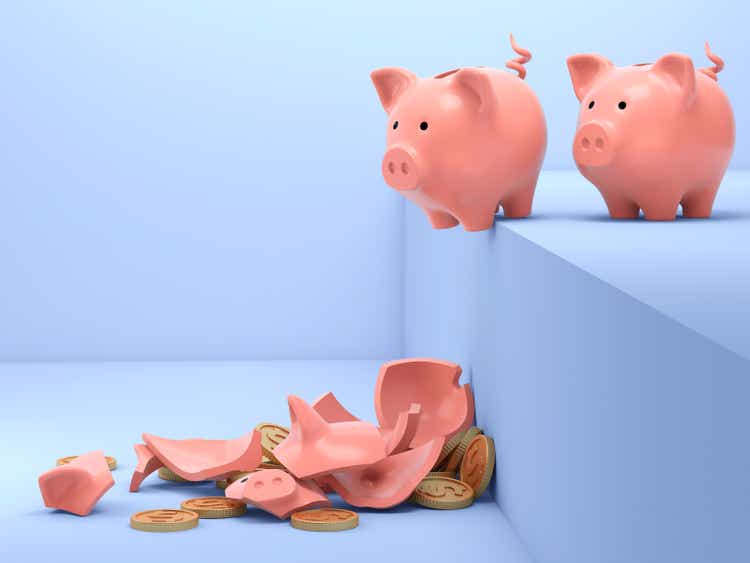 Two ceramic piggy banks with one broken into pieces on blue background