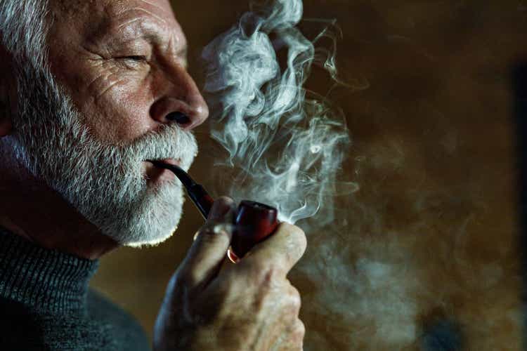 Serious mature man smoking a pipe.