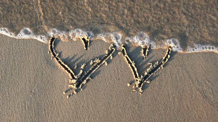 Heart Shapes Being Drawn on Sandy Beach and Wiped Out by Sea Wave at Sunset
