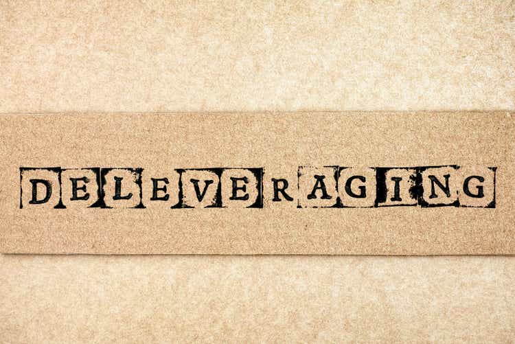 Cardboard with word Deleveraging made by black alphabet stamps.