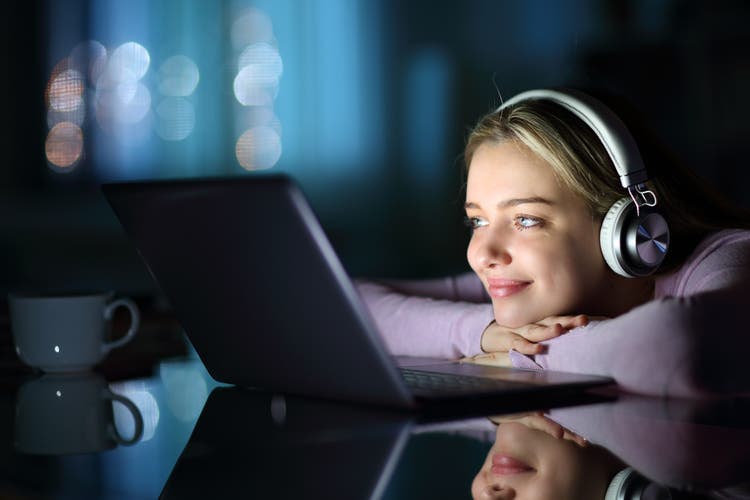 Teen trägt Kopfhörer beobachten Medien auf Laptop