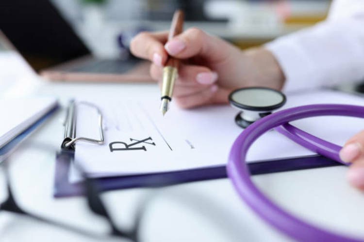 Doctor prescribes prescription drugs, stethoscope is lying next to him