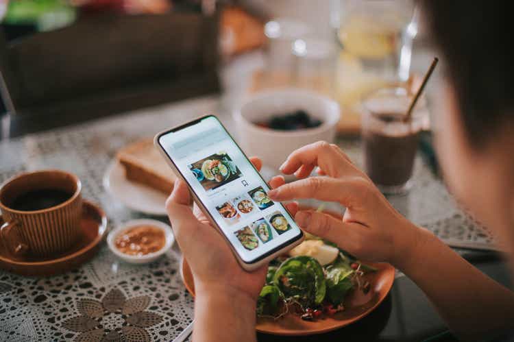 high angle view asian chinese woman"s hand on mobile app for online food delivery during breakfast time