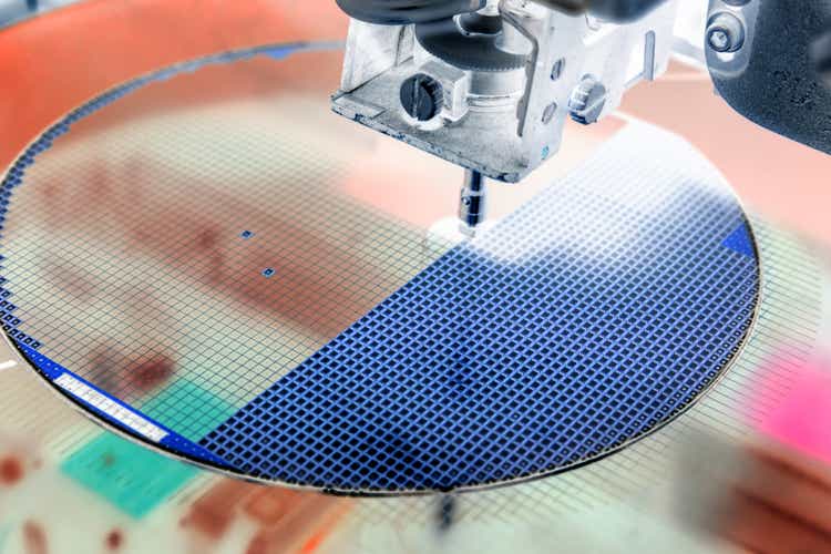 Recoja el troquel de silicio en una oblea de silicio en una máquina de abrazadera de troquel en la fabricación de semiconductores/color negativo