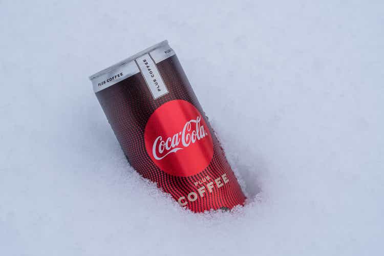 Can of Coca-Cola plus coffee on a bed of snow and white background