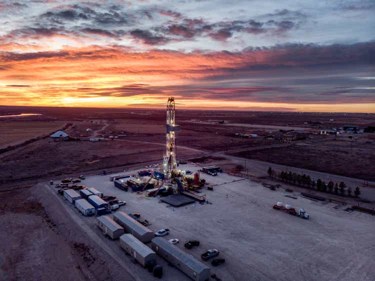 Drone View Of An Oil Or Gas Drill Fracking Rig Pad As The Sun Sets In New Mexico