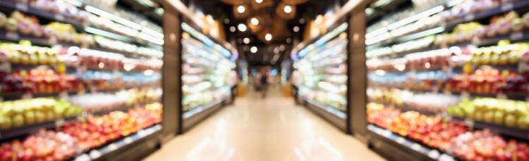 Grocery store shelves with fruits and vegetables blurred background