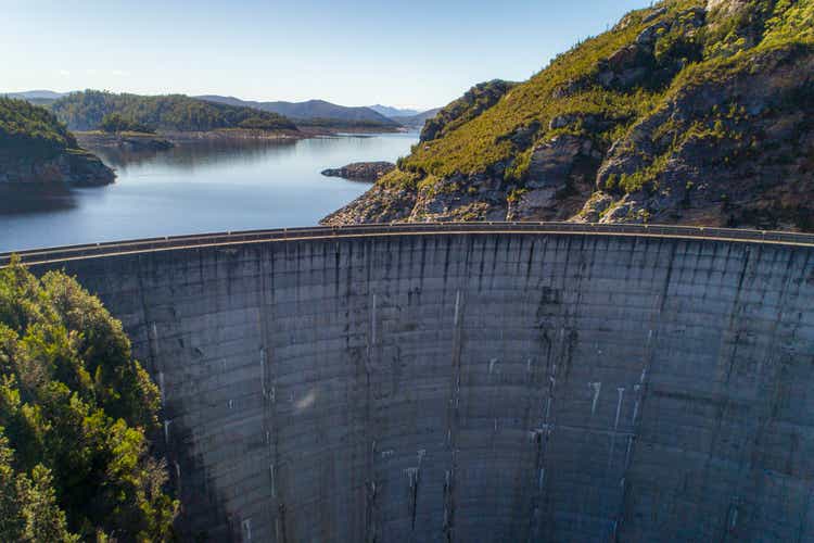 Cement dam wall creating hydro electricity aerial view
