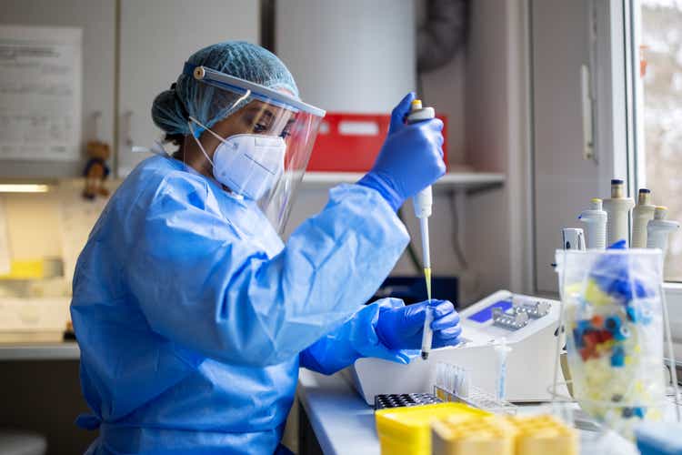 Medical scientists wearing coverall and PPE working in lab