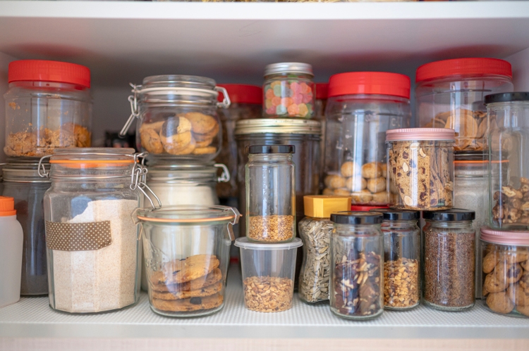 cabinet closet full of bottle of dried food, preserved food, biscuits , nuts, snack, candy, raw food, flour, cereal