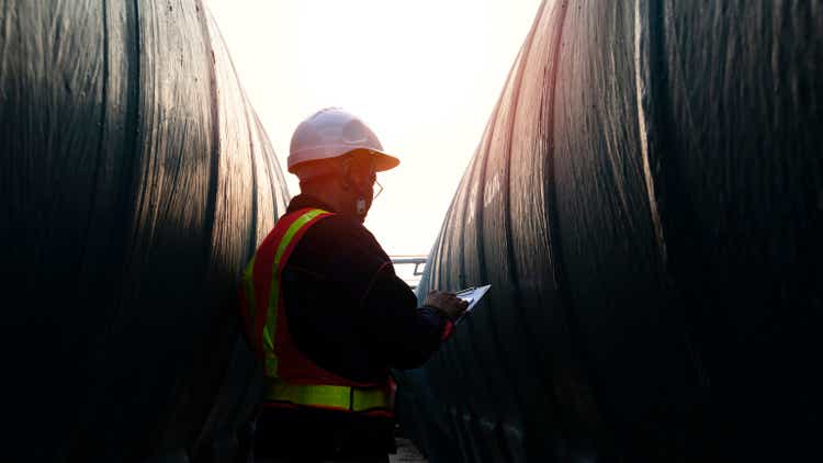 Middle age engineer dress full PPE suit hold radio communication inspection at site of factory